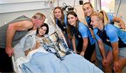 4 August 2025; TG4 All-Ireland Ladies Senior Football Champions and Dublin footballers Hannah Leahy, Aoife Kane, Aoife Curran and Carla Rowe pictured with the Brendan Martin Cup and Molly McEntaggart, aged 15, and her father Paul McEntaggart, from Naas, Kildare, during a visit by the players to Children's Health Ireland at Crumlin, Dublin. Photo by Sam Barnes/Sportsfile