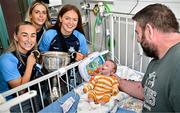 4 August 2025; TG4 All-Ireland Ladies Senior Football Champions and Dublin footballers Aoife Curran, Rebecca McDonnell and Laura Grendon pictured with the Brendan Martin Cup and Billie Madden, aged 4 weeks, and his father Willie, during a visit by the players to Children's Health Ireland at Crumlin, Dublin. Photo by Sam Barnes/Sportsfile