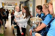 4 August 2025; TG4 All-Ireland Ladies Senior Football Champions and Dublin footballers including Orlagh Nolan and Carla Rowe pictured with the Brendan Martin Cup and Saoirse Fearon, aged 4, from Kells, Meath, and her mother Laura Fearon, during a visit by the players to Children's Health Ireland at Crumlin, Dublin. Photo by Sam Barnes/Sportsfile