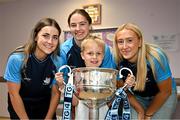 4 August 2025; TG4 All-Ireland Ladies Senior Football Champions and Dublin footballers Aoife Kane, Orlagh Nolan and Jodi Egan pictured the Brendan Martin Cup and Nate Briggs, aged 8, from Dublin, during a visit by the players to Children's Health Ireland at Crumlin, Dublin. Photo by Sam Barnes/Sportsfile