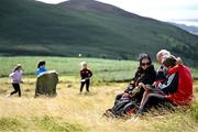 4 August 2025; Spectators, from left, Tanya, Patsy and Kate Murphy inspect the event programme while young girls have a puck around during the M. Donnelly GAA Poc Fada All-Ireland Finals at Annaverna Mountain in the Cooley Peninsula, Ravensdale, Louth. Photo by Shauna Clinton/Sportsfile