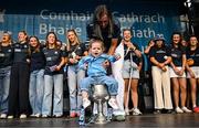 5 August 2025; Hannah Tyrrell, with her daughter Aoife, age 2, in The Brendan Martin Cup during the homecoming of TG4 All-Ireland Ladies Senior Football Champions, Dublin, at Smithfield Square in Dublin. Photo by Sam Barnes/Sportsfile