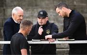 7 September 2025; Galway United management, from left, manager John Caulfield, first team coach Alan Murphy, video analyst Robbie Crosbie, and assistant manager Jon Daly in conversation before the SSE Airtricity Men's Premier Division match between Shelbourne and Galway United at Tolka Park in Dublin. Photo by Seb Daly/Sportsfile