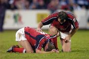16 October 2004;  Munster out-half Ronan O'Gara is attended to by team-mate Rob Henderson after getting a knock to his back. O'Gara was later substituted. Celtic League 2004-2005, Munster v Cardiff Blues, Thomond Park, Limerick. Picture credit; Brendan Moran / SPORTSFILE