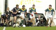 24 October 2004; Ireland players, from left, Tadhg Kennelly, Eoin Brosnan and Graham Cullen in action against Jude Bolton, Australia as a stray dog runs after the ball. Coca Cola International Rules Series 2004, Second Test, Ireland v Australia, Croke Park, Dublin. Picture credit; Damien Eagers / SPORTSFILE *** Local Caption *** Any photograph taken by SPORTSFILE during, or in connection with, the 2004 Coca Cola International Rules Series which displays GAA logos or contains an image or part of an image of any GAA intellectual property, or, which contains images of a GAA player/players in their playing uniforms, may only be used for editorial and non-advertising purposes.  Use of photographs for advertising, as posters or for purchase separately is strictly prohibited unless prior written approval has been obtained from the Gaelic Athletic Association.