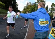 28 October 2013; Kerry footballer Colm Cooper surprised marathon runners today when he linked up with Lucozade Sport at the “Wall of Support” at the Airtricity Dublin Marathon. The Wall was located at the 20th mile at Roebuck Road, designed to help people through the infamous ‘wall’. The Wall of Support carried good luck messages from friends and family of people taking part in the marathon and Colm Cooper came along to hand out some much needed Lucozade Sport and to show his support for the thousands of runners, joggers and walkers. Pictured is Kerry footballer Colm Cooper handing out a bottle of Lucozade Sport to Robert Gilbert, Nottingham, England, during the Airtricity Dublin Marathon 2013. Roebuck Road, Dublin. Picture credit: Ramsey Cardy / SPORTSFILE