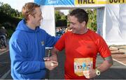 28 October 2013; Kerry footballer Colm Cooper surprised marathon runners today when he linked up with Lucozade Sport at the “Wall of Support” at the Airtricity Dublin Marathon. The Wall was located at the 20th mile at Roebuck Road, designed to help people through the infamous ‘wall’. The Wall of Support carried good luck messages from friends and family of people taking part in the marathon and Colm Cooper came along to hand out some much needed Lucozade Sport and to show his support for the thousands of runners, joggers and walkers. Pictured is Kerry footballer Colm Cooper handing out a bottle of Lucozade Sport to Alan Brady, Castlepollard, during the Airtricity Dublin Marathon 2013. Roebuck Road, Dublin. Picture credit: Ramsey Cardy / SPORTSFILE