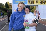28 October 2013; Kerry footballer Colm Cooper surprised marathon runners today when he linked up with Lucozade Sport at the “Wall of Support” at the Airtricity Dublin Marathon. The Wall was located at the 20th mile at Roebuck Road, designed to help people through the infamous ‘wall’. The Wall of Support carried good luck messages from friends and family of people taking part in the marathon and Colm Cooper came along to hand out some much needed Lucozade Sport and to show his support for the thousands of runners, joggers and walkers. Pictured is Kerry footballer Colm Cooper with John Kelly, from Monaghan, during the Airtricity Dublin Marathon 2013. Roebuck Road, Dublin. Picture credit: Ramsey Cardy / SPORTSFILE
