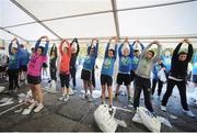 28 October 2013; A team of 25 volunteer Chartered Physiotherapists and Student Physiotherapists were located near the Finish Line at this year’s Airtricity Dublin Marathon where they provided Dynamic Cool Down and Injury Treatment facilities for race participants during Race Day. Pictured are race finishers taking part in the warm down session. Airtricity Dublin Marathon 2013, Merrion Square, Dublin. Picture credit: Pat Murphy / SPORTSFILE