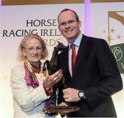 9 December 2013; Maureen Mullins, left, is presented with the National Hunt Award by Simon Coveney T.D, Minister for Agriculture, Food and the Marine, on behalf of her son Willie Mullins. Horse Racing Ireland Awards, The Pavilion, Leopardstown Racecourse, Leopardstown, Co. Dublin. Picture credit: David Maher / SPORTSFILE