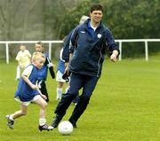 29 March 2005; Josh Breslin, age 7, takes on former Republic of Ireland international Niall Quinn during the Dublin Docklands Festival of football. This event, which takes place from 29th to 31st March, has been developed to help young people from the Docklands area of Dublin to develop their skills and come more confident and accomplished players. Teaching the soccer skills are soccer stars Niall Quinn, Ray Houghton, Don Givens, Bobby Saxton and Chris Nichol. Tolka Rovers FC, Frank Cooke Park, Griffith Avenue, Dublin. Picture credit; Brendan Moran / SPORTSFILE