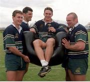 6 October 1999; Australia's Tim Horan is carried in an inflatable chair by team-mates, from left, Jason Little, John Eales and Richard Harry at a squad training session in Portmarnock after he broke the Guinness try challenge during their game against Romania.Tim scored Australia's first try in under 119.5 seconds, the time it takes to pour the perfect pint of Guinness. As a result, Tim received a year's supply of Guinness and there was a £10,000 donation to the charity of Tim's choice. Australia Rugby Squad Training, Portmarnock Hotel and Golf Links, Dublin. Picture credit: Brendan Moran / SPORTSFILE