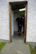 17 April 2005; Armagh manager Joe Kernan 'assisted' by Armagh Secretary Paddy Og Nugent sweep rain water from the entrance to a dressing room in advance of a pitch inspection which resulted in the match being called off. Allianz National Football League, Division 1 Semi-Final, Mayo v Armagh, Dr. Hyde Park, Roscommon. Picture credit; Ray McManus / SPORTSFILE