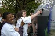20 April 2005; Ethiopian Olympic legend Haile Gebreselaisse with helps Special Olympic athlete Orla Daly from Foxrock, Dublin, return her Trocaire box while Trocaire Ireland Director Justin Kilcullen, partially hidden, looks on at a photocall to help Trocaire close its Lenten campaign. St. Stephen's Green, Dublin. Picture credit; Pat Murphy / SPORTSFILE
