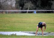 12 February 2014; A competitor uses a puddle to wash off mud after the race in the Aviva Leinster Schools Cross Country Championships. Santry Demesne, Santry, Co. Dublin. Picture credit: Ramsey Cardy / SPORTSFILE