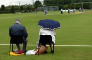 9 July 2005; Two spectators shelter from a shower during the game. ICC Trophy Semi-Final, Scotland v Bermuda, The Hills, Milverton, Skerries, Co. Dublin. Picture credit; David Maher / SPORTSFILE