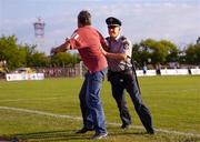 14 July 2005; A local man who encroached onto the pitch is removed by a member of the local Police force. UEFA Cup, First Qualifying Round, First Leg, FK Ekranas v Cork City, Aukstaitija, Panevezys, Lithuania. Picture credit; Brian Lawless / SPORTSFILE