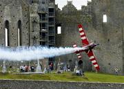 21 July 2005; Pilot Mike Mangold, USA, in his Edge 540 aircraft, flies by the Rock of Cashel, during the pilots practice run in advance of Sunday's Red Bull Air Race. Cashel, Co. Tipperary. Picture credit; David Maher / SPORTSFILE