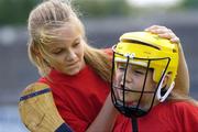 16 August 2005; Leanne Kearney, left, aged 12, from Sean McDermott St., helps her sister Sinead, aged 9, with her helmet during the Docklands Festival of Gaelic Football and Hurling. The Festival was developed to help young people from the Docklands further develop their hurling and football skills and become more confident and accomplished players. Parnell Park, Dublin. Picture credit; Brian Lawless / SPORTSFILE