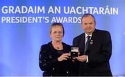 14 March 2014; Máire Ní Cheallaigh, Raheny, Dublin, is presented with her GAA President's Awards for 2014 award by Uachtarán Chumann Lúthchleas Gael Liam Ó Néill. Máire was born into a dedicated GAA family – her father won an All-Ireland media in 1953 with Kerry and after playing camogie with UCD she was elected as Cathaoirleach of the club. She has also served on the Comhairle Committee liaising with clubs and currently is the Camogie representative on the national Féile Committee, Cathaoirleach of the Volunteer Committee and Cathaoirleach of the Leinster Coiste Cultúr agus Gaeilge. Picture credit: Pat Murphy / SPORTSFILE