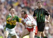 25 September 2005; Brian Dooher, Tyrone, is tackled by Tomas O Se, Kerry, watched by referee Michael Monahan. Bank of Ireland All-Ireland Senior Football Championship Final, Kerry v Tyrone, Croke Park, Dublin. Picture credit; Brendan Moran / SPORTSFILE *** Local Caption *** Any photograph taken by SPORTSFILE during, or in connection with, the 2005 Bank of Ireland All-Ireland Senior Football Final which displays GAA logos or contains an image or part of an image of any GAA intellectual property, or, which contains images of a GAA player/players in their playing uniforms, may only be used for editorial and non-advertising purposes.  Use of photographs for advertising, as posters or for purchase separately is strictly prohibited unless prior written approval has been obtained from the Gaelic Athletic Association.
