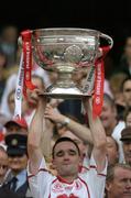 25 September 2005; Tyrone's Ryan McMenamin lifts the Sam Maguire Cup after the game. Bank of Ireland All-Ireland Senior Football Championship Final, Kerry v Tyrone, Croke Park, Dublin. Picture credit; Brendan Moran / SPORTSFILE *** Local Caption *** Any photograph taken by SPORTSFILE during, or in connection with, the 2005 Bank of Ireland All-Ireland Senior Football Final which displays GAA logos or contains an image or part of an image of any GAA intellectual property, or, which contains images of a GAA player/players in their playing uniforms, may only be used for editorial and non-advertising purposes.  Use of photographs for advertising, as posters or for purchase separately is strictly prohibited unless prior written approval has been obtained from the Gaelic Athletic Association.
