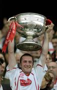 25 September 2005; Tyrone's Stephen O'Neill lifts the Sam Maguire Cup after the game. Bank of Ireland All-Ireland Senior Football Championship Final, Kerry v Tyrone, Croke Park, Dublin. Picture credit; Brendan Moran / SPORTSFILE *** Local Caption *** Any photograph taken by SPORTSFILE during, or in connection with, the 2005 Bank of Ireland All-Ireland Senior Football Final which displays GAA logos or contains an image or part of an image of any GAA intellectual property, or, which contains images of a GAA player/players in their playing uniforms, may only be used for editorial and non-advertising purposes.  Use of photographs for advertising, as posters or for purchase separately is strictly prohibited unless prior written approval has been obtained from the Gaelic Athletic Association.