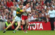 25 September 2005; Ryan McMenamin, Tyrone, is tackled by Marc O Se, Kerry. Bank of Ireland All-Ireland Senior Football Championship Final, Kerry v Tyrone, Croke Park, Dublin. Picture credit; Brendan Moran / SPORTSFILE *** Local Caption *** Any photograph taken by SPORTSFILE during, or in connection with, the 2005 Bank of Ireland All-Ireland Senior Football Final which displays GAA logos or contains an image or part of an image of any GAA intellectual property, or, which contains images of a GAA player/players in their playing uniforms, may only be used for editorial and non-advertising purposes.  Use of photographs for advertising, as posters or for purchase separately is strictly prohibited unless prior written approval has been obtained from the Gaelic Athletic Association.