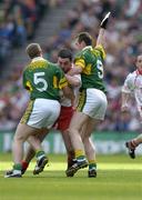25 September 2005; Ryan Mellon, Tyrone, is tackled by Tomas O Se (5) and William Kirby, Kerry. Bank of Ireland All-Ireland Senior Football Championship Final, Kerry v Tyrone, Croke Park, Dublin. Picture credit; Brendan Moran / SPORTSFILE *** Local Caption *** Any photograph taken by SPORTSFILE during, or in connection with, the 2005 Bank of Ireland All-Ireland Senior Football Final which displays GAA logos or contains an image or part of an image of any GAA intellectual property, or, which contains images of a GAA player/players in their playing uniforms, may only be used for editorial and non-advertising purposes.  Use of photographs for advertising, as posters or for purchase separately is strictly prohibited unless prior written approval has been obtained from the Gaelic Athletic Association.