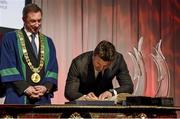 22 March 2014; Former Ireland Rugby International Brian O'Driscoll signs the roll of honour after receiving the Freedom of the City of Dublin from the Dublin Lord Mayor Oisín Quinn. Mansion House, Dublin. Picture credit: Matt Browne / SPORTSFILE