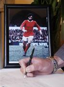 28 November 2005; A member of the public signs a book of condolence for the late George Best at the offices of the Football Association of Ireland. Merrion Square, Dublin. Picture credit: Damien Eagers / SPORTSFILE
