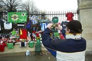 2 December 2005; A George Best supporter takes a photograph outside stormont gates before the funeral of George Best. Belfast, Co. Antrim. Picture credit: Damien Eagers / SPORTSFILE