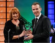 2 March 2014; Anne Browne is presented with the International  player of the year award on behalf of her son Alan Browne, from Nagle, Co. Cork, and playing for Preston North End, by Republic of Ireland International Glenn Whelan. Three FAI International Football Awards, RTE Studios, Donnybrook, Dublin. Picture credit: David Maher / SPORTSFILE