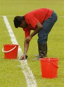 20 January 2006; Enajasuraj Malaya, from India, endeavours to remove a white line, incorrectly painted by a colleague, before training in advance of the 2006 Vodafone All-Stars Hurling game. Singapore Polo Club, Singapore. Picture credit; Ray McManus / SPORTSFILE