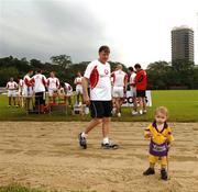 20 January 2006; Donal O'Grady walks past a possible star of the future three year old Ruaidhri Newille, from Hong Kong, in advance of the 2006 Vodafone All-Stars Hurling game. Singapore Polo Club, Singapore. Picture credit; Ray McManus / SPORTSFILE