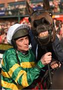 21 April 2014; Jockey Barry Geraghty attempts to kiss Shutthefrontdoor after winning the Boylesports Irish Grand National Steeplechase. Fairyhouse Easter Festival, Fairyhouse, Co. Meath. Picture credit: Brendan Moran / SPORTSFILE