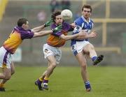 5 February 2006; Noel Garvan, Laois, in action against Ciaran Deely and Redmond Barry, left, Wexford. Allianz National Football League, Division 1B, Round 1, Laois v Wexford, O'Moore Park, Portlaoise, Co. Laois. Picture credit: Brian Lawless / SPORTSFILE