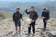 16 May 2014; Legendary GAA Commentator Mícheál Ó Muircheartaigh lifts the Sam Maguire Cup on the summit of Carrauntoohil, MacGillycuddy's Reeks, Co. Kerry, with programme director and former Galway star Alan Kerins, left, and Tom Prendergast, 1969 Kerry All- Ireland winner, during the 'Sam to Summit' in aid of the Alan Kerins Project which saw Sam Maguire and representatives and players with All-Ireland football medals from each of the 32 counties reach the top of Ireland’s highest mountain. Carrauntoohil, Co. Kerry. Picture credit: Valerie O'Sullivan / SPORTSFILE