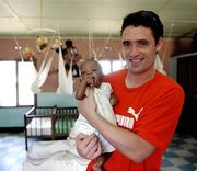 28 March 2006; Galway hurler, Alan Kerins, with baby John at the Cheshire Home for Vulnerable and Orphaned Children in Kaoma, Zambia. Picture credit: Damien Eagers / SPORTSFILE
