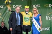 18 May 2014; Stage winner Robert McCarthy, An Post Chain Reaction, is presented with the yellow jersey by Peter Hanley, Delivery Services Manager, An Post, and Miss An Post Ruth McCourt after winning the opening stage of the 2014 An Post Rás. Dunboyne - Roscommon. Picture credit: Ramsey Cardy / SPORTSFILE
