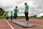 22 May 2014; Nine year old Sean McCarthy takes part in the standing long jump watched by Irish Long Jump record holder Kelly Proper during the launch of the Forest Feast Athletics Summer Camp. Morton Stadium, Santry, Dublin. Picture credit: Matt Browne / SPORTSFILE