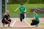 22 May 2014; Eleven year old Robert McCarthy takes part in the long jump watched by Irish Long Jump record holder Kelly Proper, right, and Christine Whelan, Forest Feast Sales Manager Ireland, during the launch of the Forest Feast Athletics Summer Camp. Morton Stadium, Santry, Dublin. Picture credit: Matt Browne / SPORTSFILE