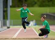 22 May 2014; Eleven year old Robert McCarthy takes part in the long jump watched by Irish Long Jump record holder Kelly Proper during the launch of the Forest Feast Athletics Summer Camp. Morton Stadium, Santry, Dublin. Picture credit: Matt Browne / SPORTSFILE