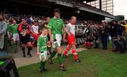 29 May 1999; Niall Quinn of Republic of Ireland with mascot Christopher Gallagher and Iain Dowie of Northern Ireland walk out prior to the International Friendly match between Republic of Ireland and Northern Ireland at Lansdowne Road in Dublin. Photo by Ray McManus/Sportsfile