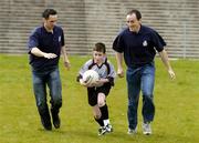 20 April 2006; Eoin Fox is tackled by Cavan footballer Paul Brady, left, and Tyrone footballer Brian Dooher at the launch of the Ulster Vhi Cúl Camps. Inter county stars from all over Ulster were present to announce details of the popular Summer Camps which start on July 3rd. The Vhi Cúl Camps are a nationally co-ordinated programme that aims to encourage children to learn and develop sporting and life-skills by particpating in Gaelic Games, in a fun, non-competitive environment. Gaelic Grounds, Armagh. Picture credit: Damien Eagers / SPORTSFILE