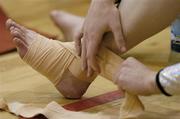 22 April 2006; A gymnast straps up her ankle before competing. National Team Gymnastics Championships, National Basketball Arena, Tallght, Dublin. Picture credit: Brendan Moran / SPORTSFILE