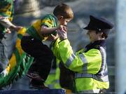 23 April 2006; A member of the Garda Siochana helps a young Kerry supporter over the fence during the game. Allianz National Football League, Division 1 Final, Kerry v Galway, Gaelic Grounds, Limerick. Picture credit: David Maher / SPORTSFILE