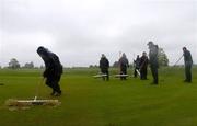 21 May 2006; Green keeper Cormac Comerford, left, makes one last effort as his work-mates look on, before it was announced that play would be suspended until tomorrow. Nissan Irish Open Golf Championship. Carton House Golf Club, Maynooth, Co. Kildare. Picture credit; Brian Lawless / SPORTSFILE
