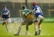 21 May 2006; Gary Hanniffy, Offaly, and James Young, Laois, compete for possession in the atrocious conditions. Guinness Leinster Senior Hurling Championship, Quarter-final, Laois v Offaly, O'Moore Park, Portlaoise, Co. Laois. Picture credit; Brendan Moran / SPORTSFILE