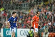8 June 2014; Cavan's Darra McVeety, and Armagh's Kevin Dyas during a rain shower in the second half. Ulster GAA Football Senior Championship, Quarter-Final, Armagh v Cavan, Athletic Grounds, Armagh. Picture credit: Ramsey Cardy / SPORTSFILE